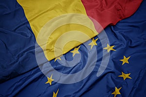 Waving colorful flag of european union and national flag of romania