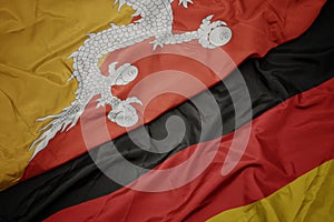 waving colorful flag of germany and national flag of bhutan