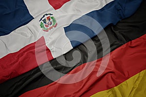 waving colorful flag of germany and national flag of dominican republic