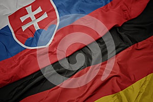 Waving colorful flag of germany and national flag of slovakia