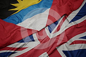 waving colorful flag of great britain and national flag of antigua and barbuda photo