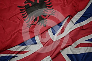 waving colorful flag of great britain and national flag of albania