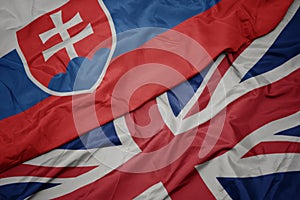 Vlající barevná vlajka Velké Británie a státní vlajka slovenska