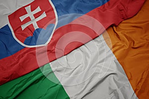 Waving colorful flag of ireland and national flag of slovakia