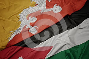 waving colorful flag of jordan and national flag of bhutan