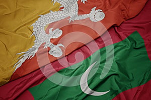 waving colorful flag of maldives and national flag of bhutan