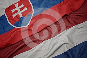 Waving colorful flag of netherlands and national flag of slovakia