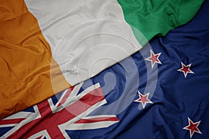 waving colorful flag of new zealand and national flag of cote divoire