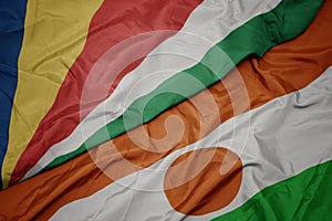 waving colorful flag of niger and national flag of seychelles