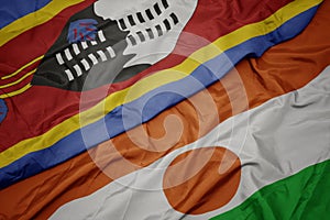 waving colorful flag of niger and national flag of swaziland