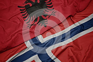 waving colorful flag of norway and national flag of albania