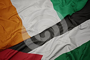 waving colorful flag of palestine and national flag of cote divoire