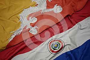 waving colorful flag of paraguay and national flag of bhutan