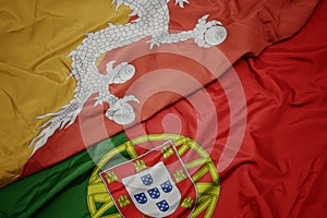 waving colorful flag of portugal and national flag of bhutan