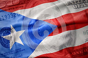 waving colorful flag of puerto rico on a american dollar money background. finance concept