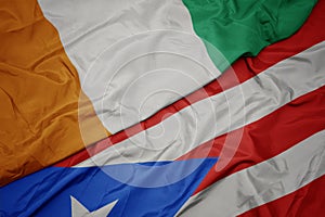 waving colorful flag of puerto rico and national flag of cote divoire
