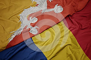 waving colorful flag of romania and national flag of bhutan