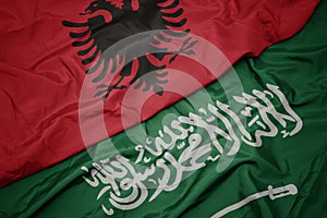waving colorful flag of saudi arabia and national flag of albania