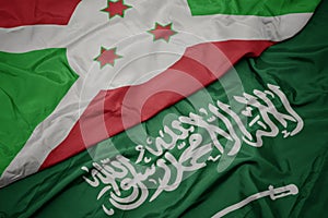 waving colorful flag of saudi arabia and national flag of burundi