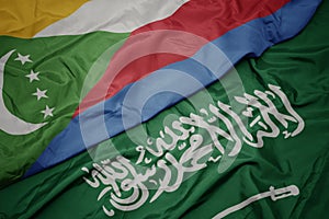 waving colorful flag of saudi arabia and national flag of comoros