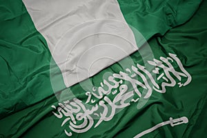 waving colorful flag of saudi arabia and national flag of nigeria