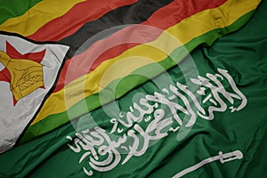 waving colorful flag of saudi arabia and national flag of zimbabwe