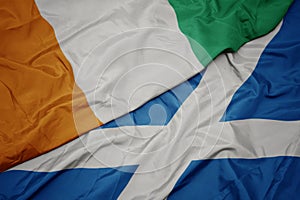 waving colorful flag of scotland and national flag of cote divoire