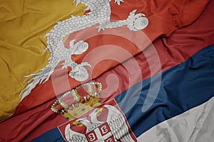 waving colorful flag of serbia and national flag of bhutan