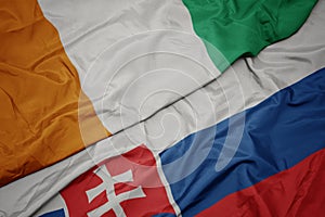 waving colorful flag of slovakia and national flag of cote divoire