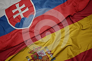 Waving colorful flag of spain and national flag of slovakia