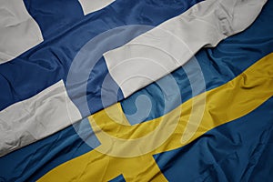 waving colorful flag of sweden and national flag of finland