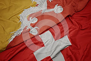 waving colorful flag of switzerland and national flag of bhutan