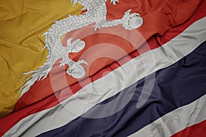 waving colorful flag of thailand and national flag of bhutan