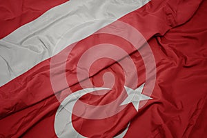 waving colorful flag of turkey and national flag of austria