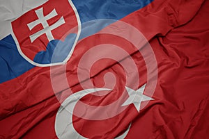 Waving colorful flag of turkey and national flag of slovakia