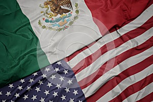 waving colorful flag of united states of america and national flag of mexico
