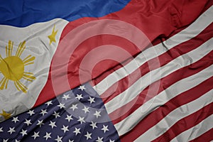 waving colorful flag of united states of america and national flag of philippines photo