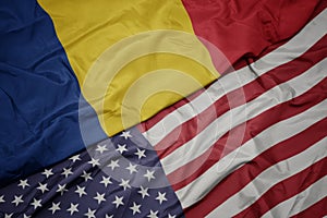 waving colorful flag of united states of america and national flag of romania. macro