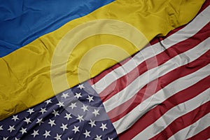 waving colorful flag of united states of america and national flag of ukraine. macro