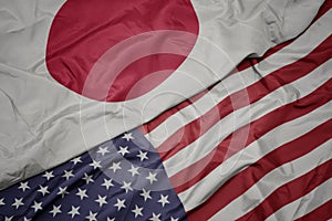 waving colorful flag of united states of america and national flag of japan