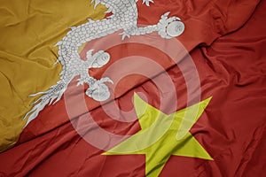 waving colorful flag of vietnam and national flag of bhutan