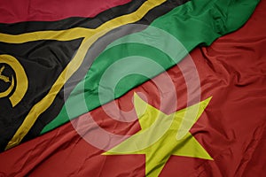 waving colorful flag of vietnam and national flag of Vanuatu