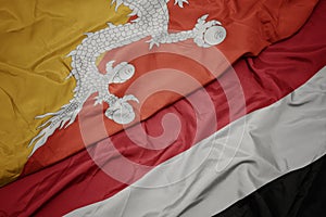 waving colorful flag of yemen and national flag of bhutan