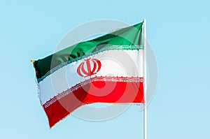 Mávání barvitý írán vlajka na modrá obloha 