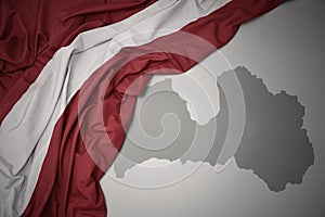 Waving colorful national flag and map of latvia.