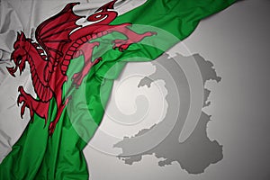 Waving colorful national flag and map of wales.