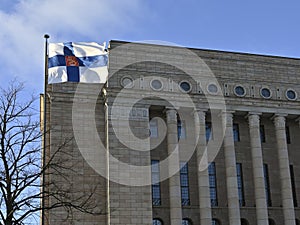 waving Finnish flag and Finnish parliament building