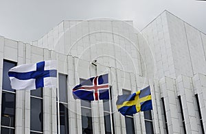 Waving Finnish, Swedish, Icelandic flags against of Finlandia Ha photo