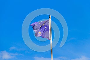 Waving flag of European Union against blue sky