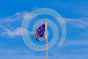 Waving flag of European Union against blue sky